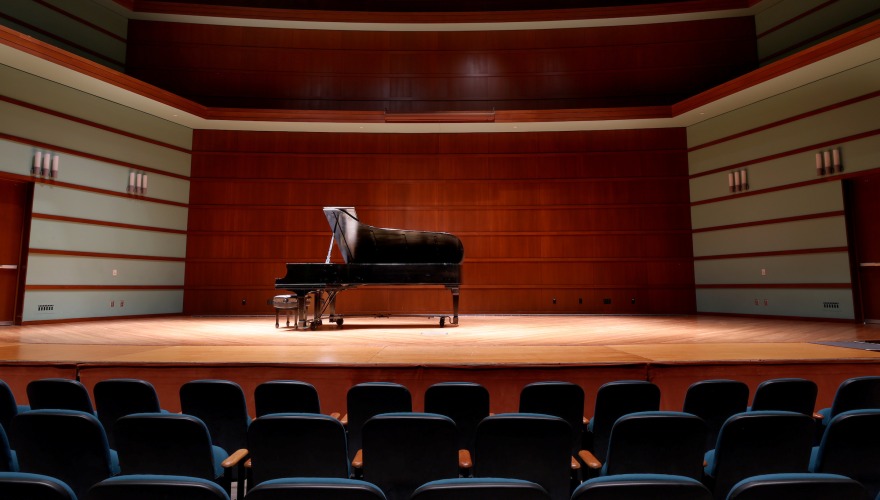 The Sebring-Lewis stage with a grand piano under a spotlight